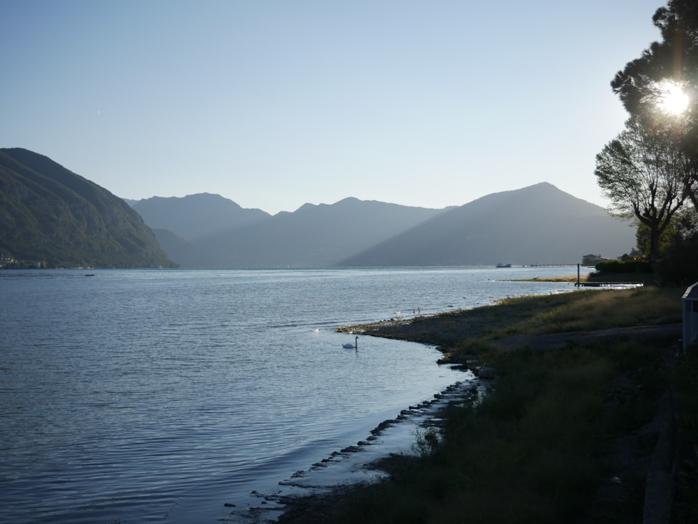 a body of water with grass and hills around it