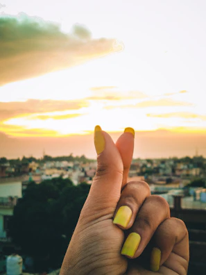 Bright summer-themed nails with vibrant yellow polish and tiny sun motifs.