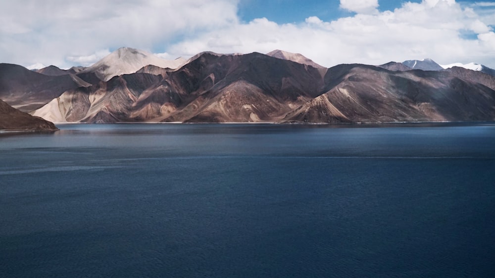 a body of water with mountains in the background