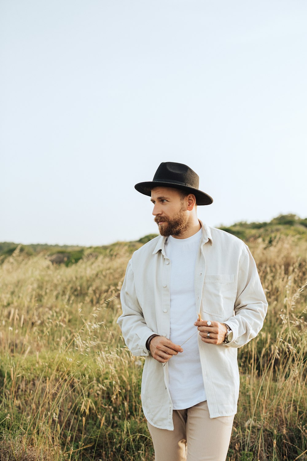 a man in a hat standing in a field
