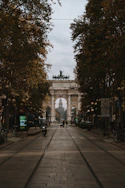 a stone archway with trees and bicycles