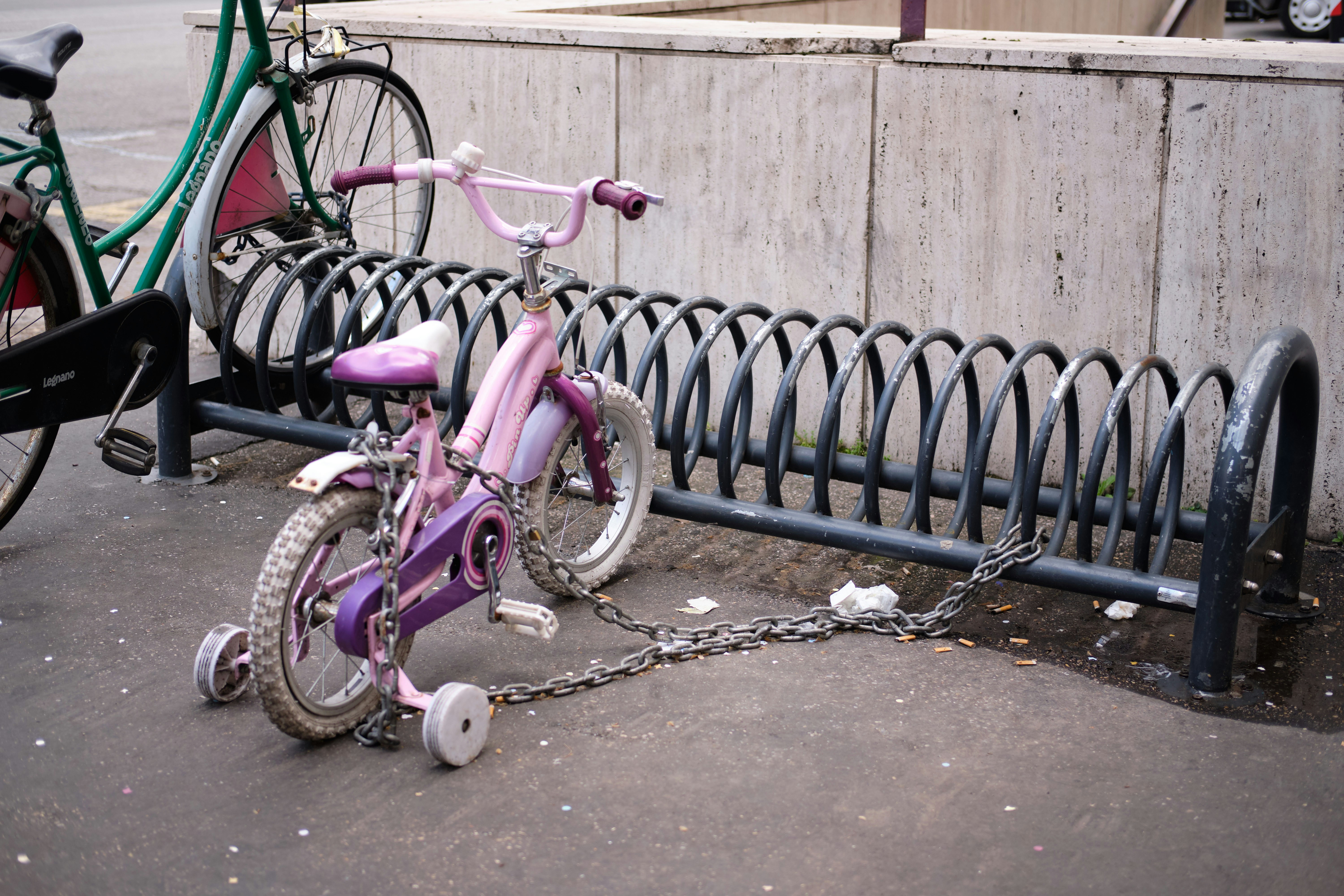 a pink bike parked on a sidewalk