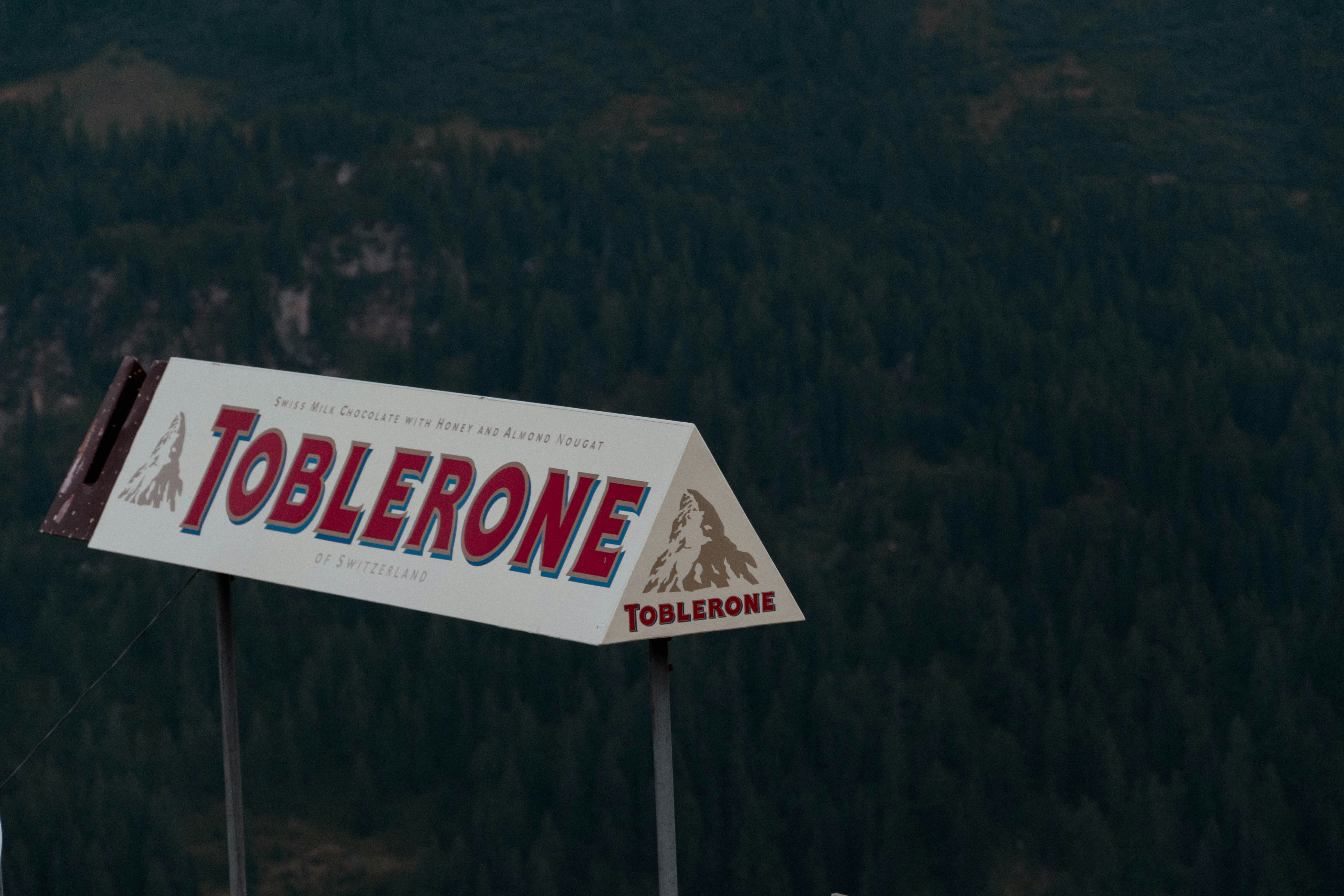 a sign with a mountain in the background