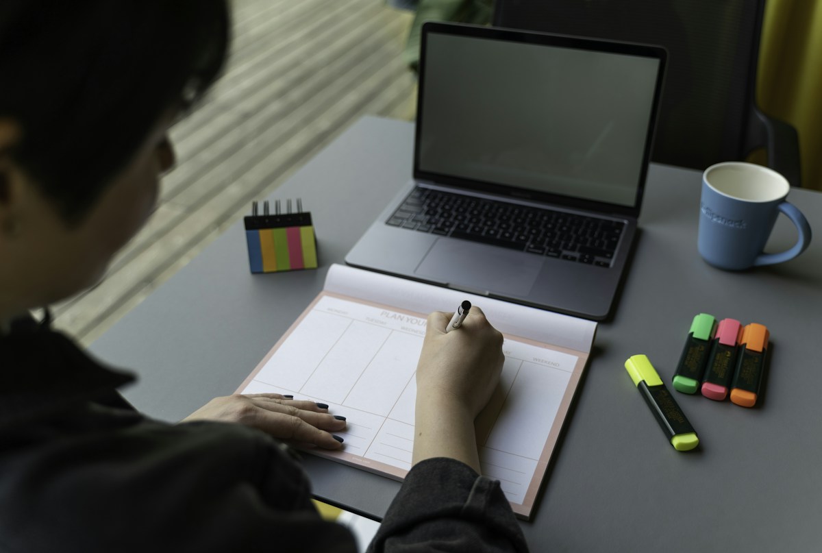 A man filling out a volunteer sign-up form at a desk with a pen.