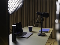 A creative workspace with colorful notes, microphones, and a coffee cup, showing the behind-the-scenes of news creation.