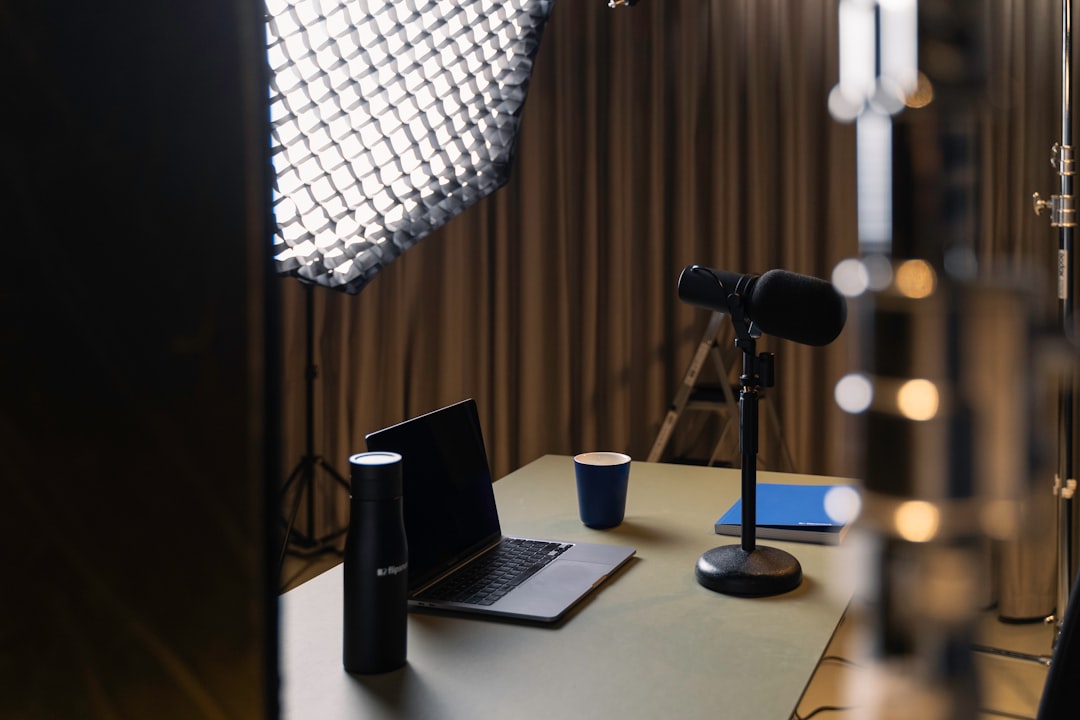 a laptop on a table, Podcast studio essentials: lighting, microphone, laptop