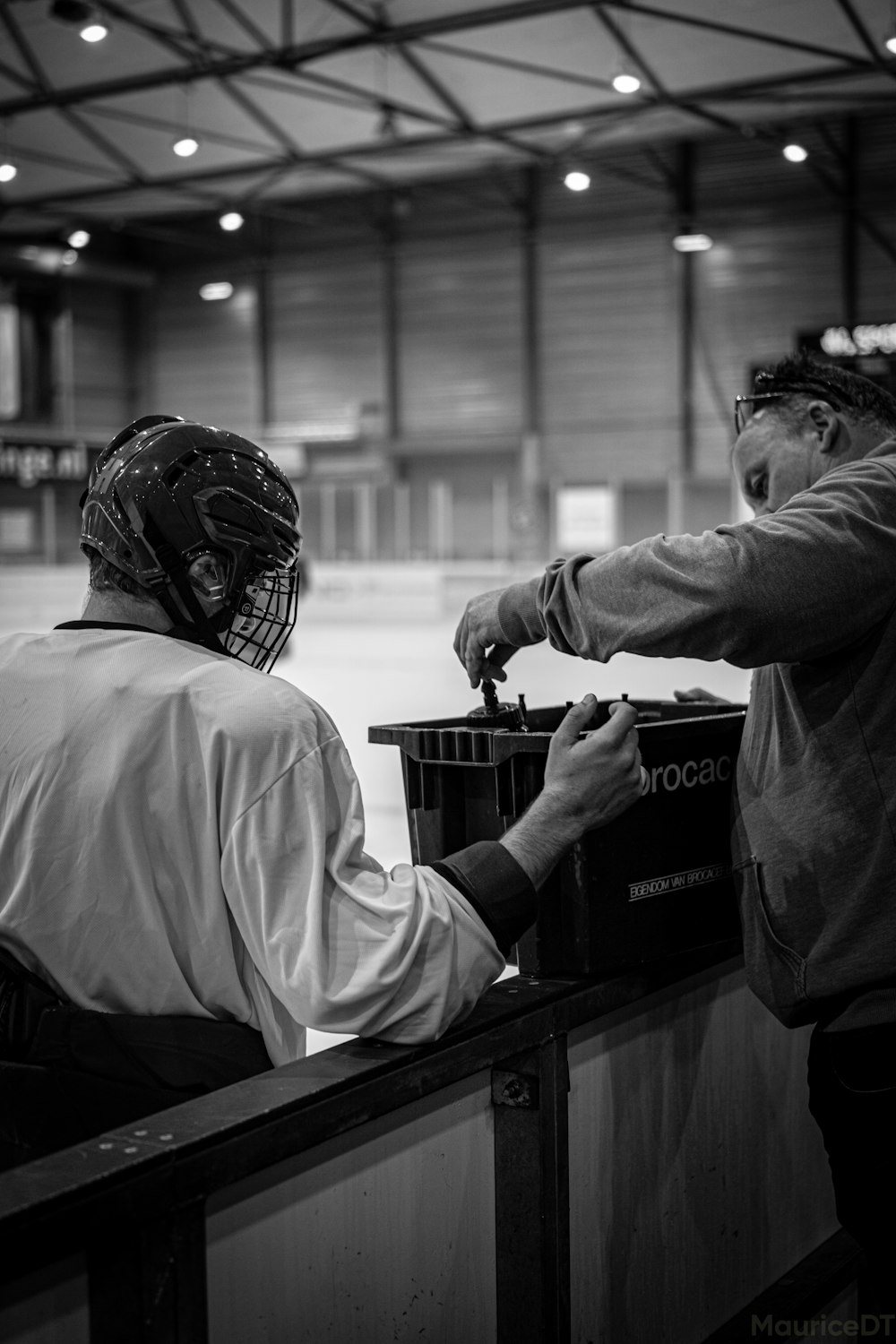 a man in a helmet pointing at a man in a mask