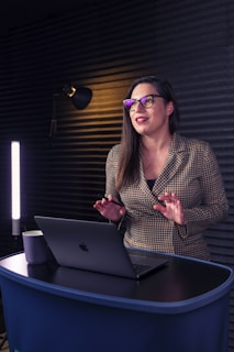 a woman sitting at a table with a laptop