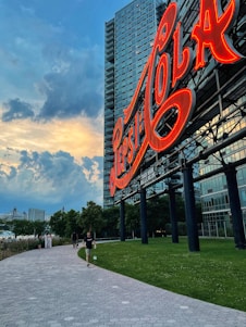 A freshly restored billboard glowing warmly at sunset, surrounded by a lively community park.