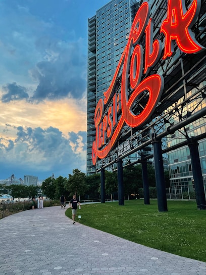 A freshly restored billboard glowing warmly at sunset, surrounded by a lively community park.