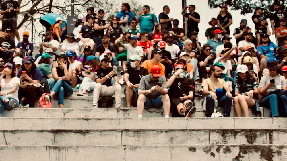 Eine Menschenmenge sitzt an einer Wand