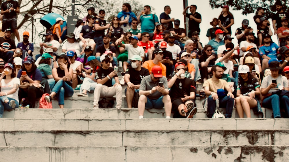 a crowd of people sitting on a wall