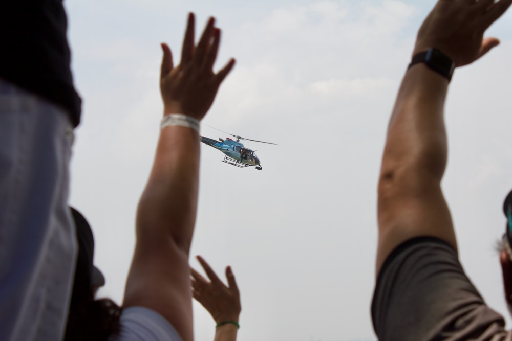 um grupo de pessoas observando um helicóptero