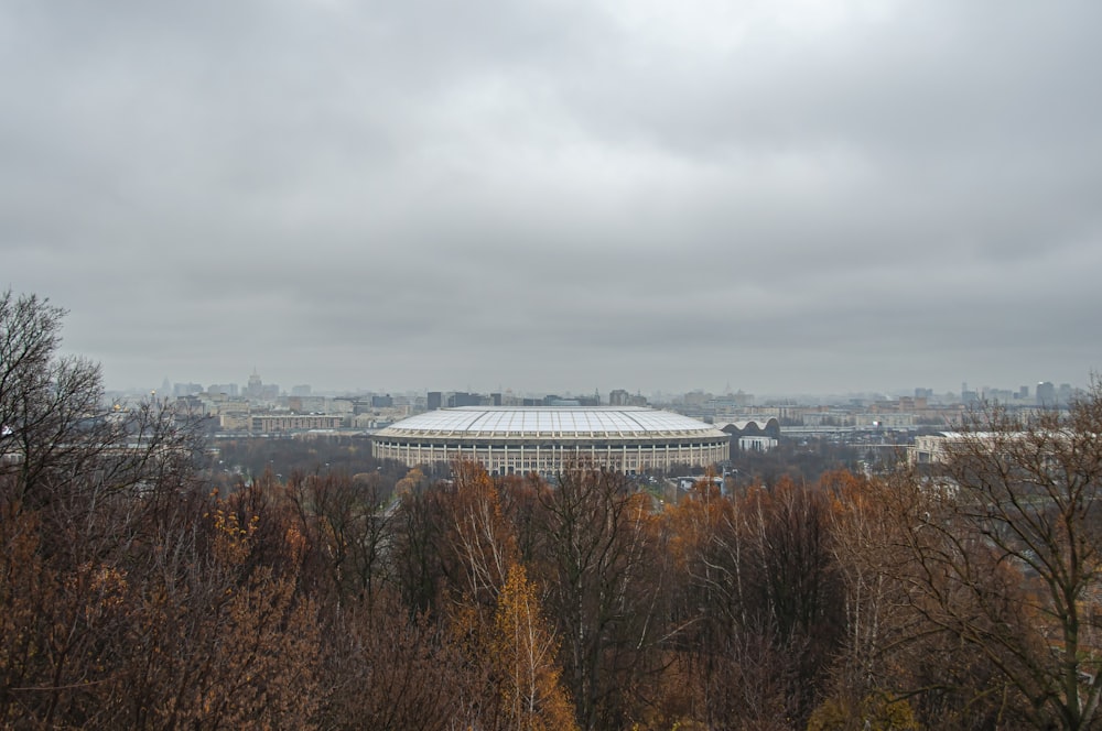 a large building with a dome roof surrounded by trees