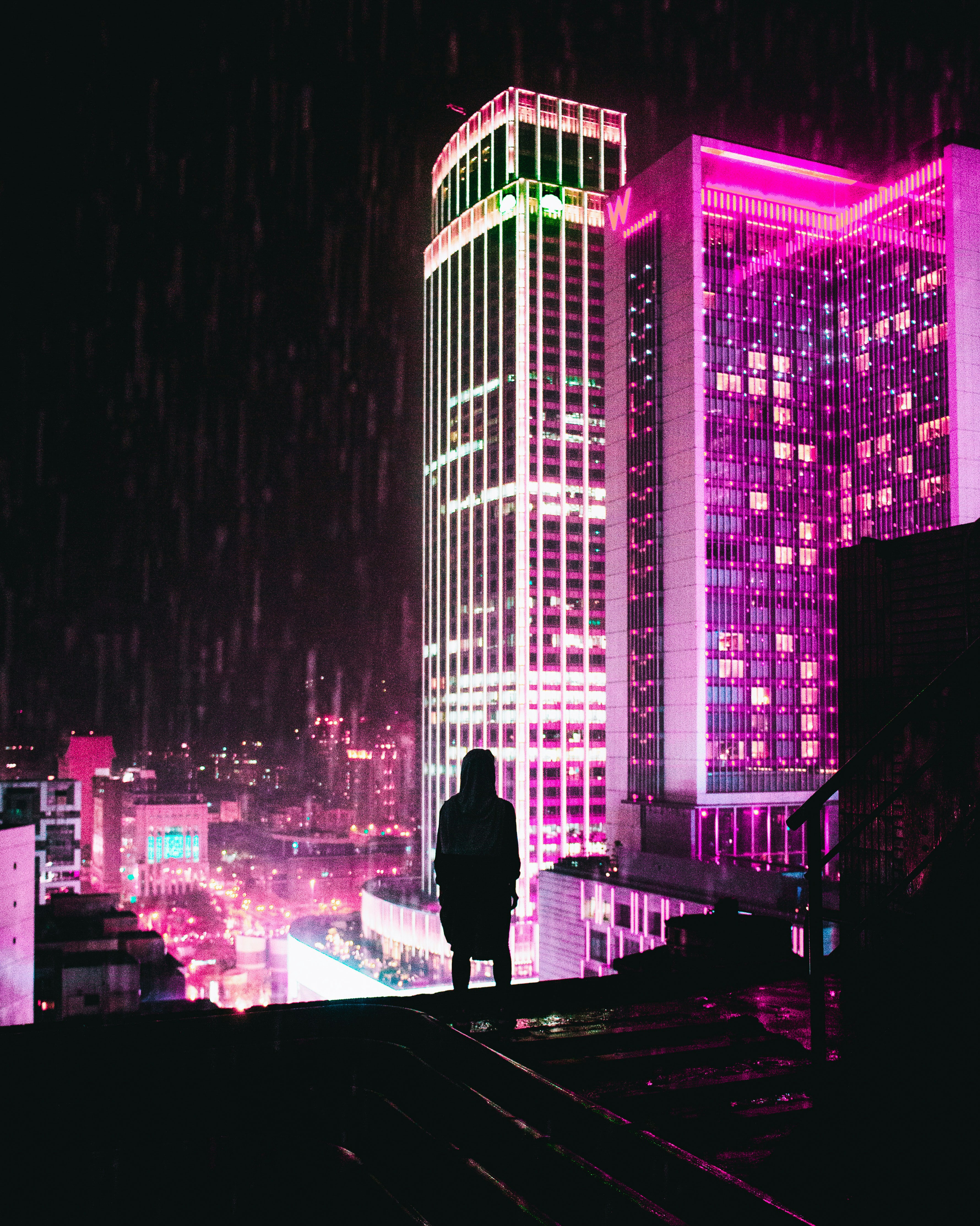 Foto Una persona parada frente a un edificio con luces – Imagen Taipéi ...