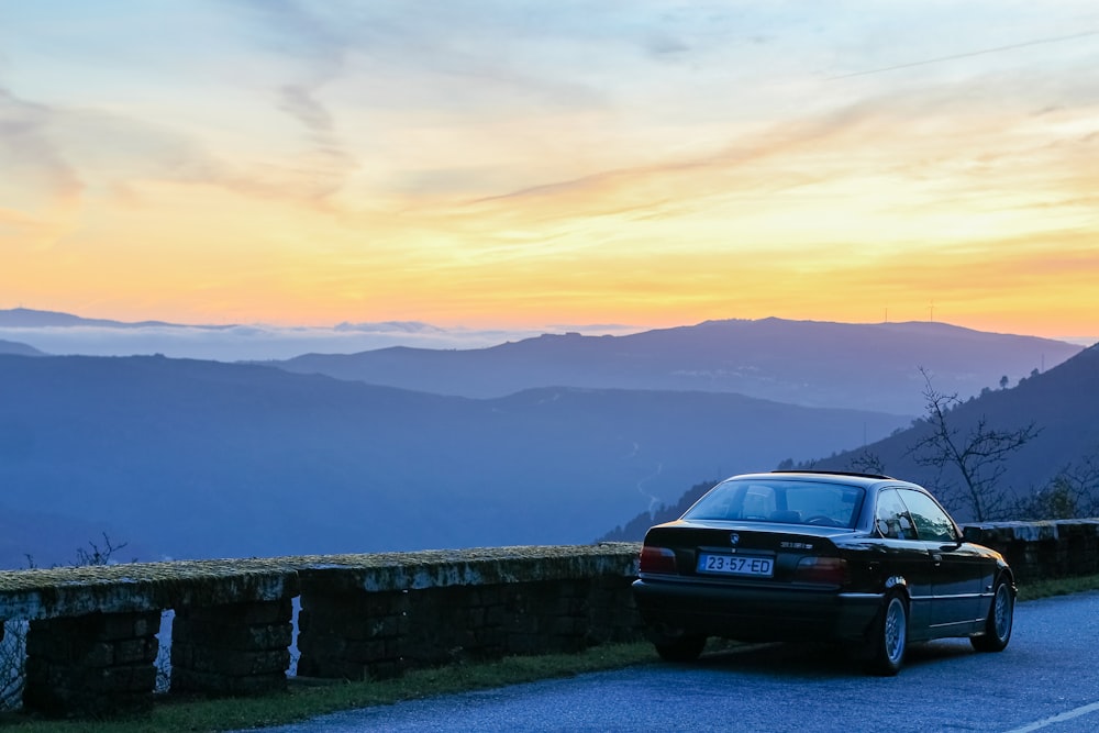 a car parked on a road with mountains in the background