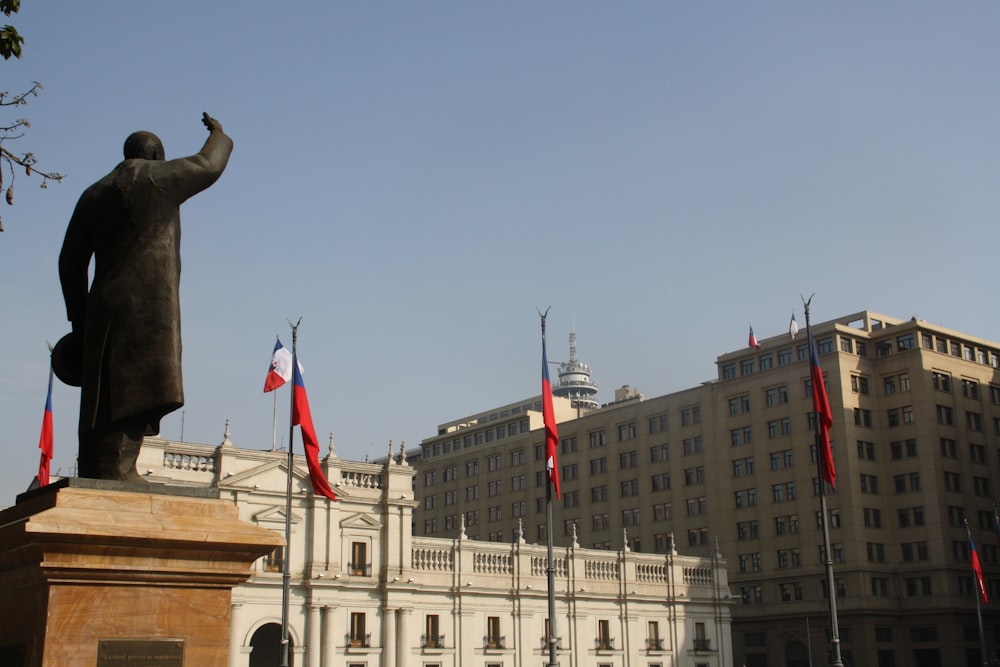 uma estátua de uma pessoa segurando uma bandeira na frente de um edifício