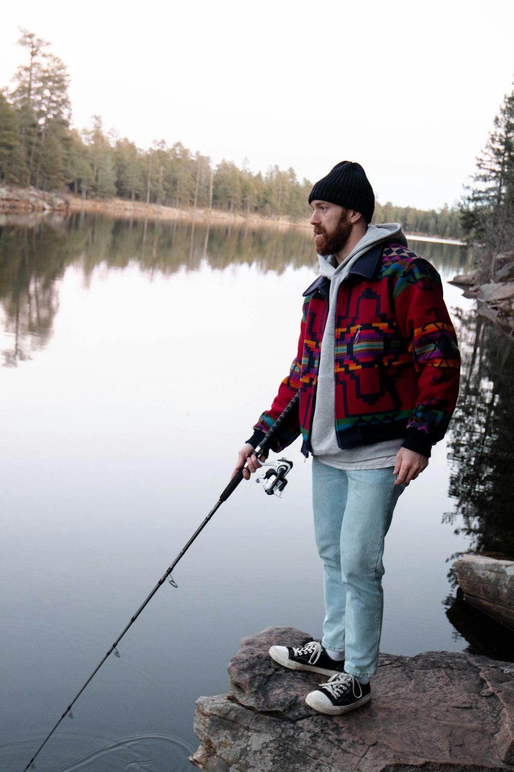 Un uomo che pesca su una roccia