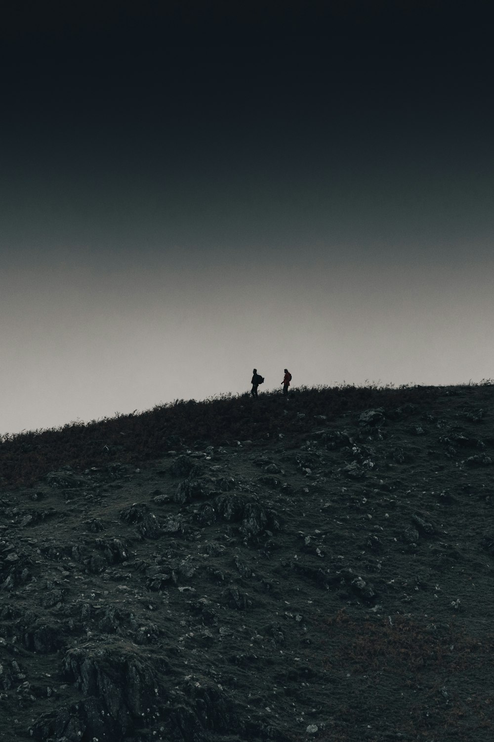 a group of people walking on a hill at night