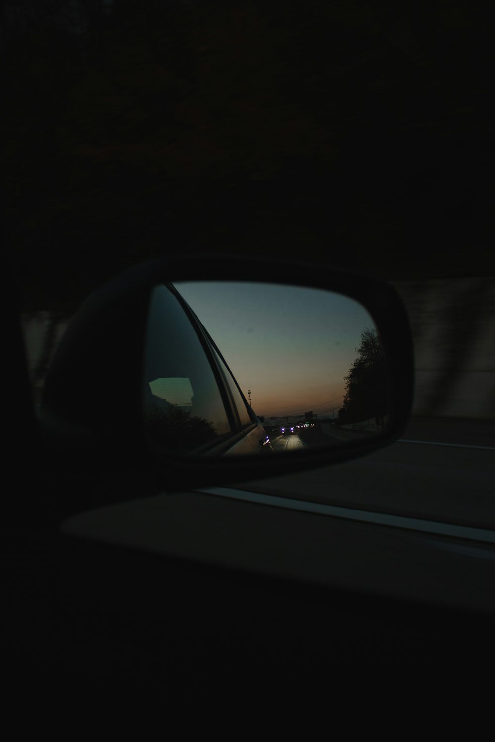 a car mirror showing a sunset