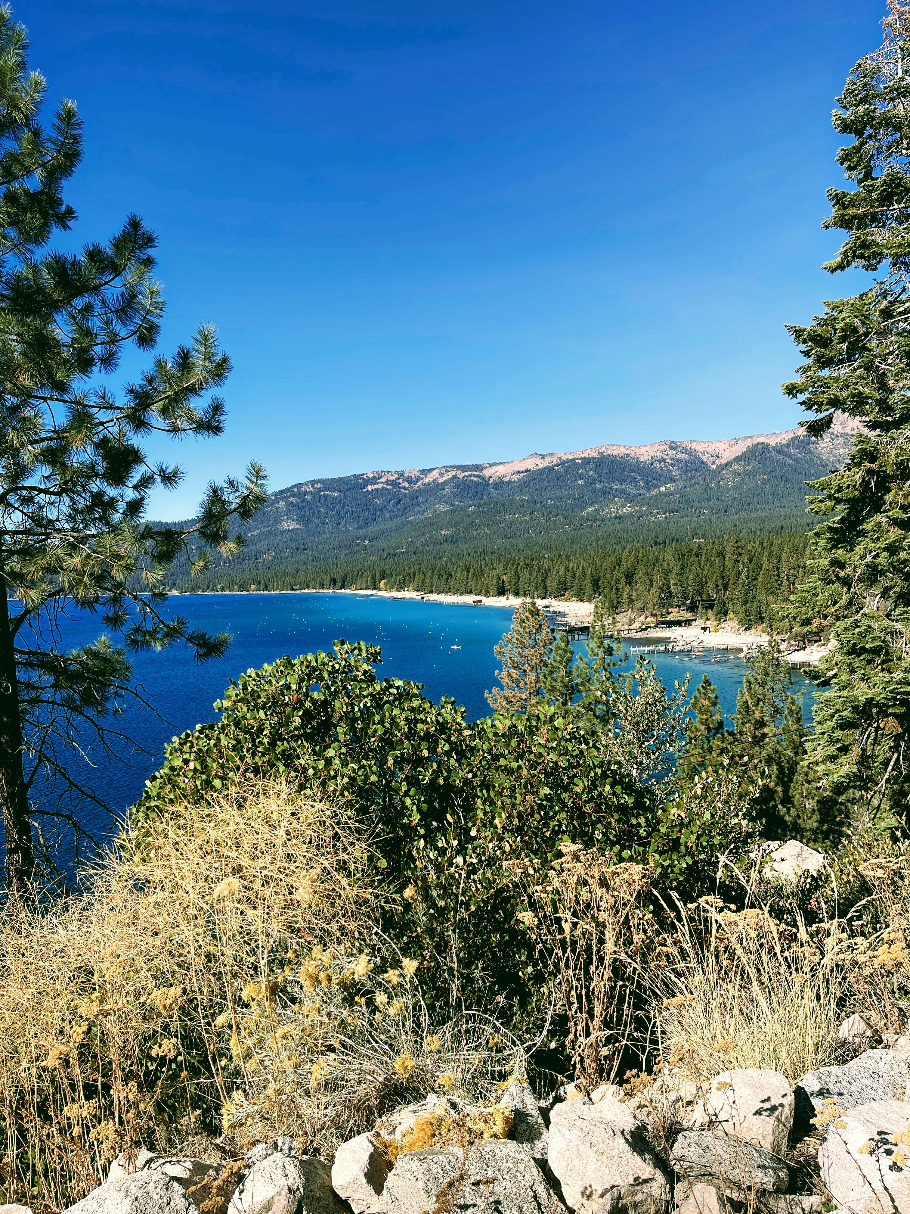 A scenic view of luxury homes along Lake Tahoe’s shoreline in Incline Village, Nevada, with mountains in the background.