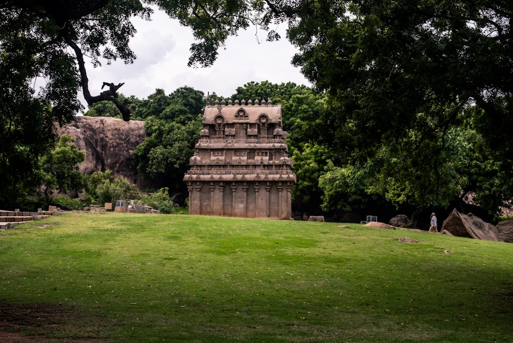 a stone structure in a grassy field