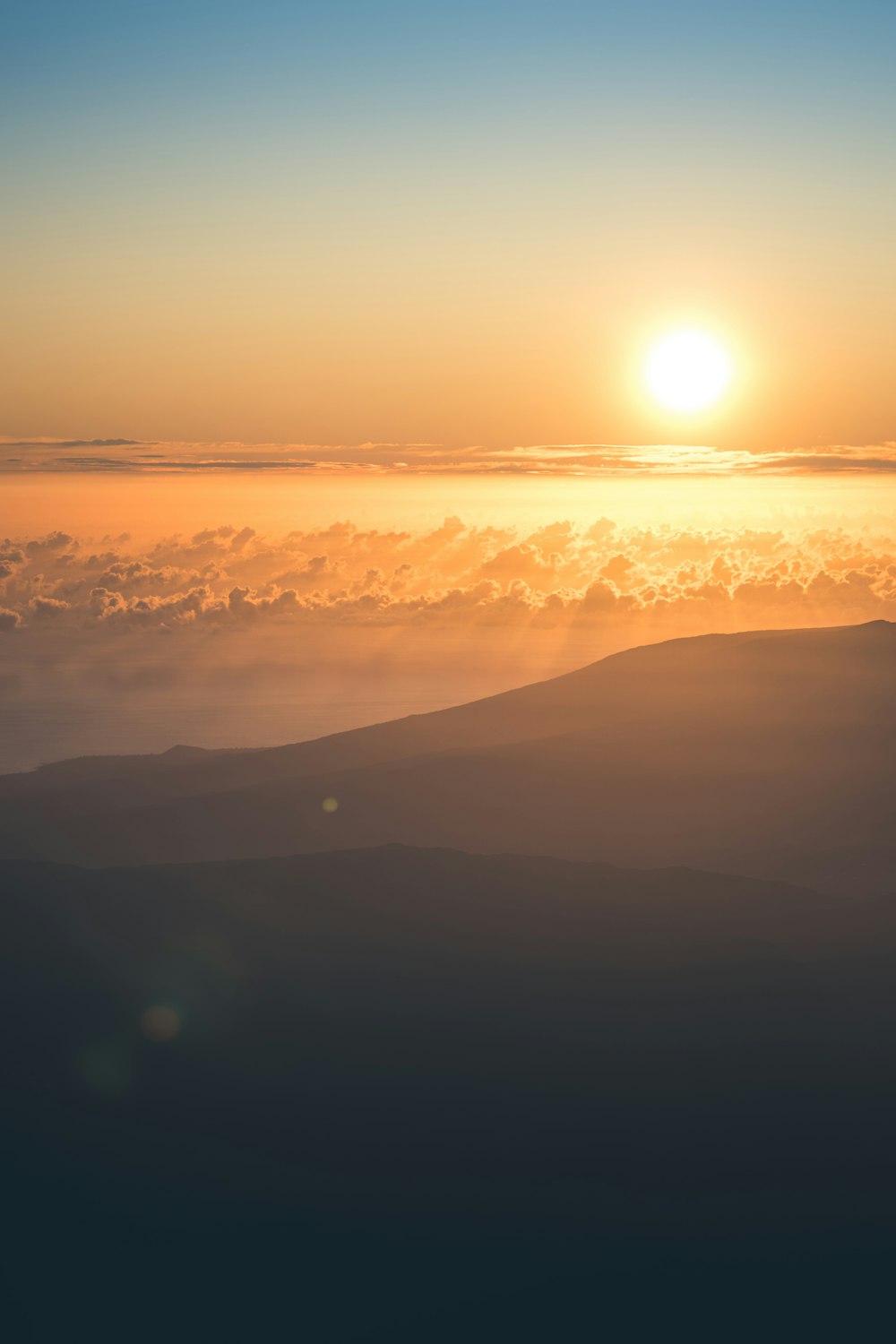 a view of the sun over a mountain range