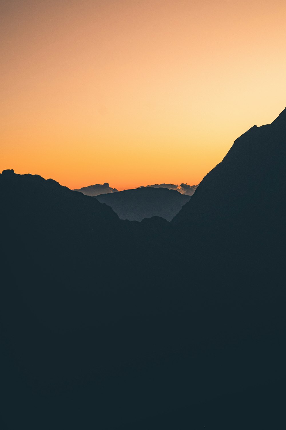 Una catena montuosa con un tramonto