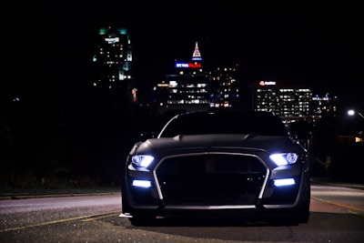 a car parked on the side of a road with buildings in the background