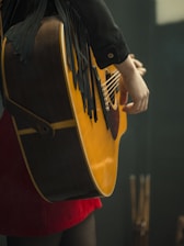 a person holding a black and yellow guitar