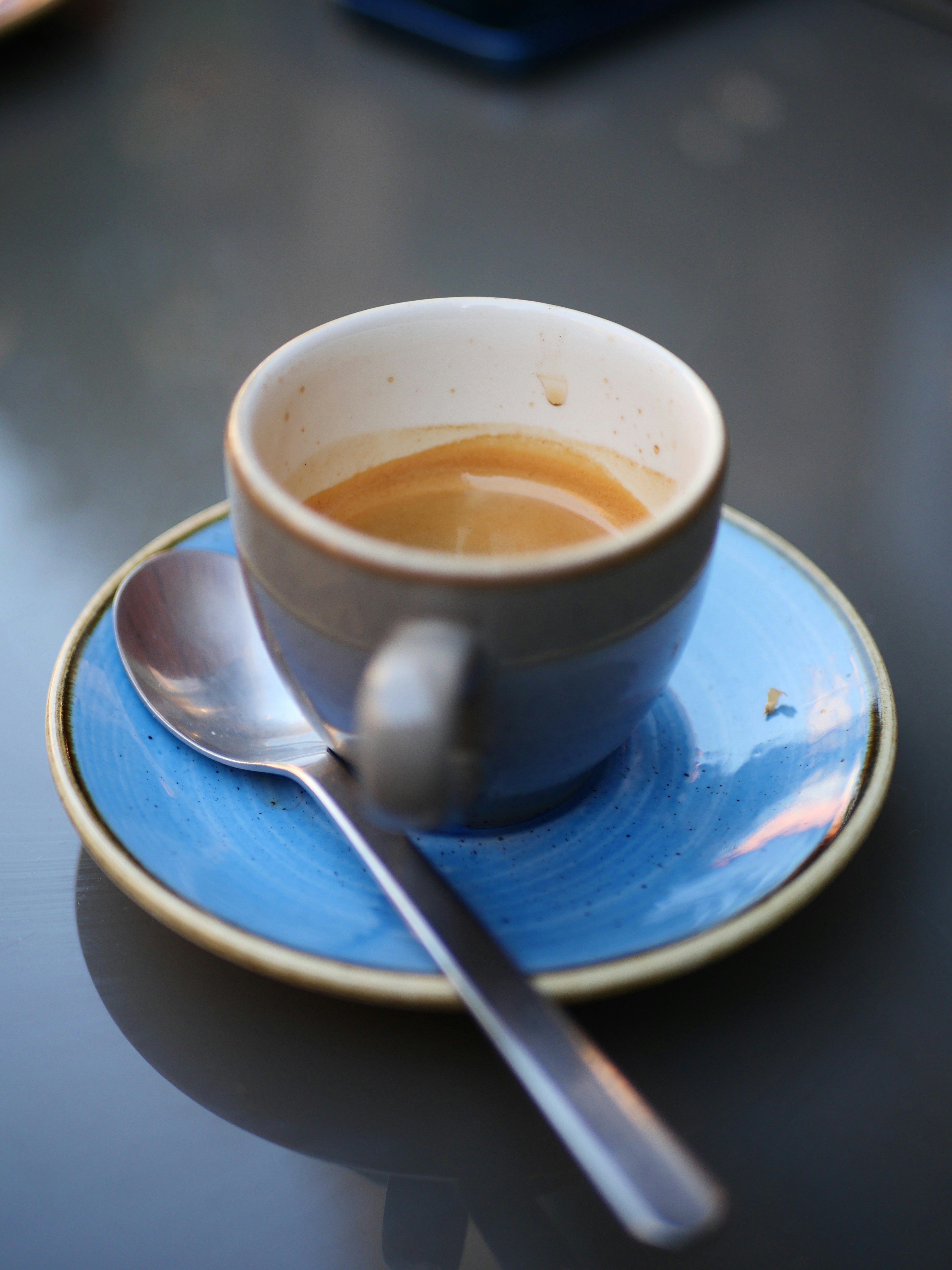 a cup of coffee on a saucer with a spoon