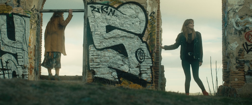 a person standing next to a wall with a painting on it