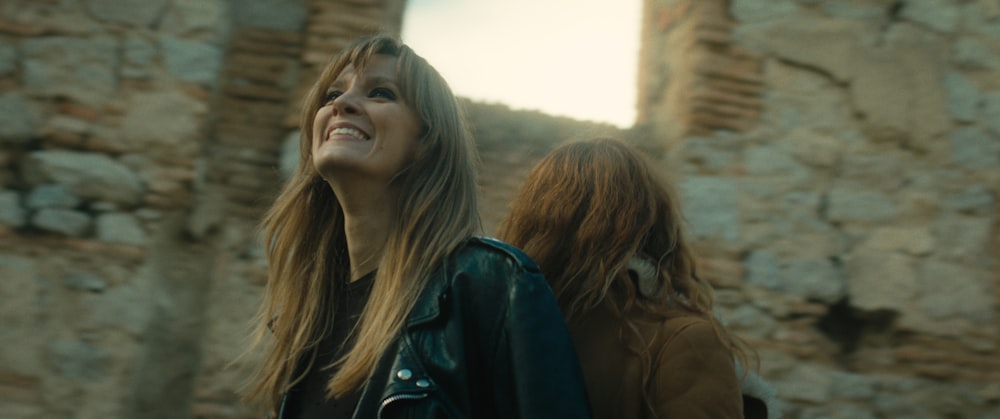 a woman smiling next to another woman