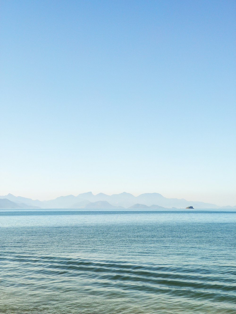 a body of water with mountains in the background