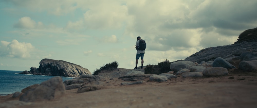 a man standing on a rocky beach