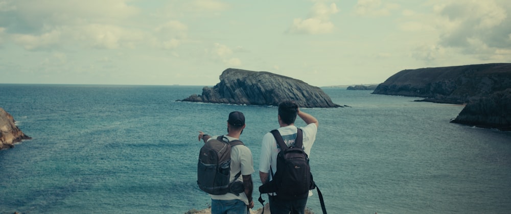 a couple of people looking at the ocean