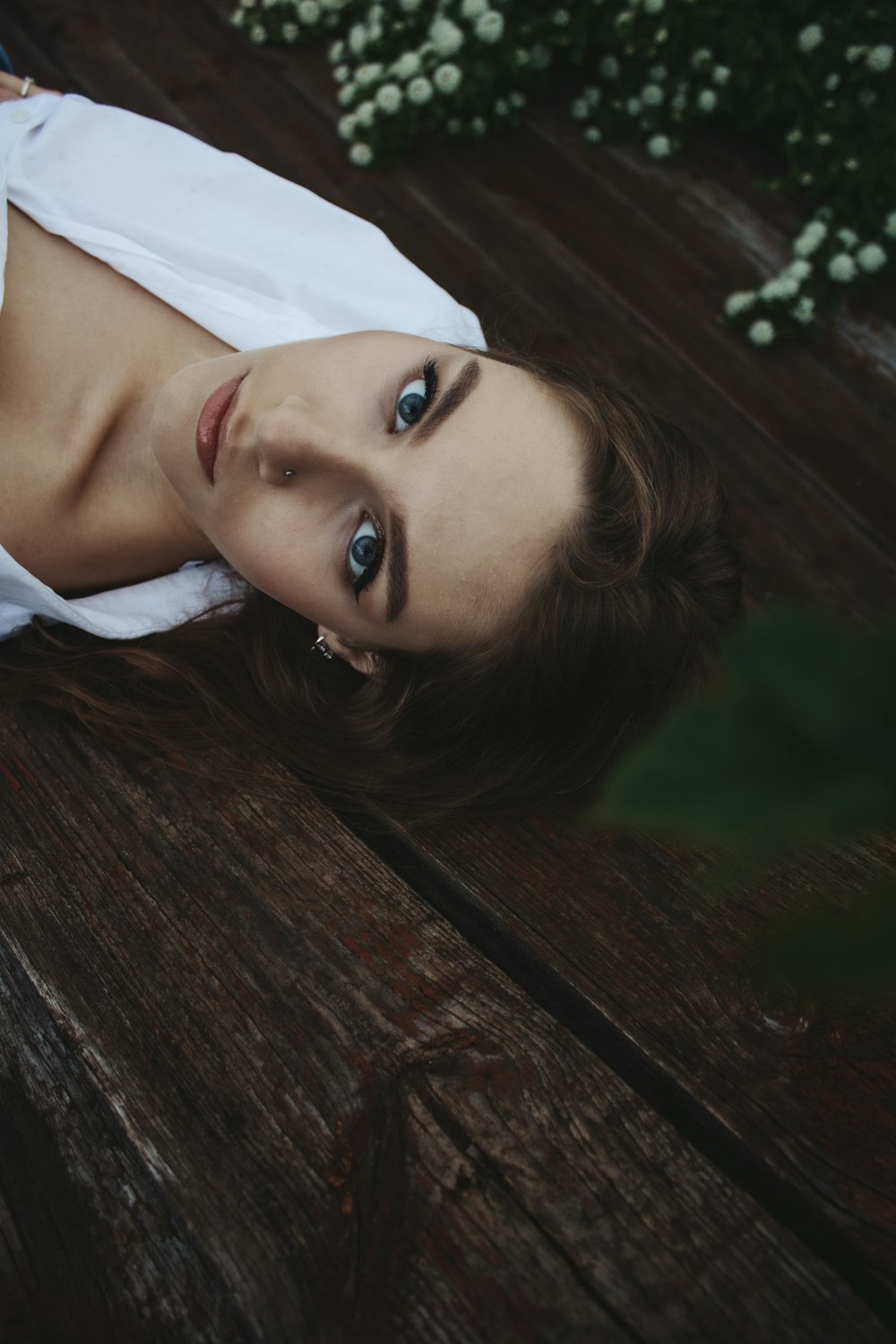 a person with a white shirt and blue eyes standing outside