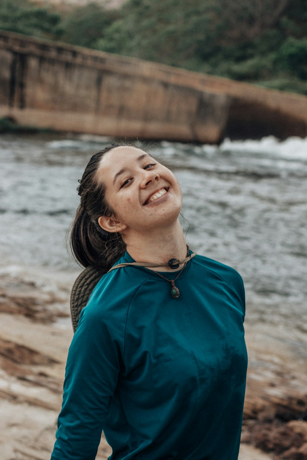 a person smiling by a river