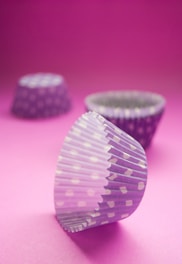 Close-up of elegant cupcake wrappers in black, turquoise, and pink tones.