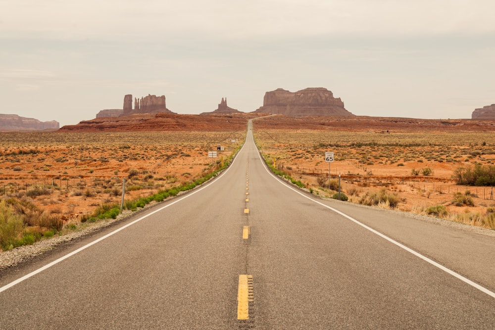 a road with a large rock formation in the distance