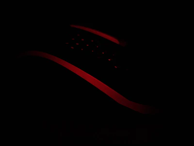 Dynamic shot of an exclusive item illuminated by subtle yellow lighting on black.