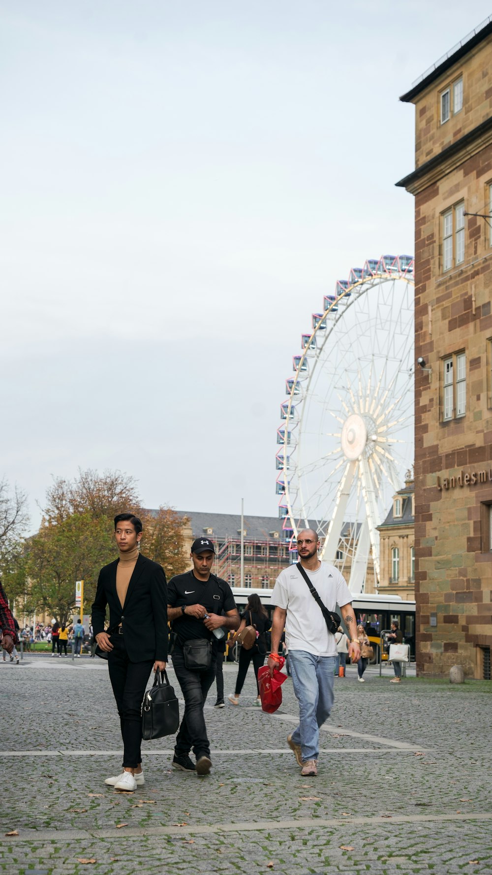 a group of people posing for a photo in front of a ferris wheel