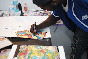 Close-up of a student painting a vibrant science diagram on paper