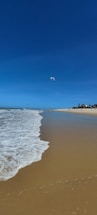A serene beach at Mauritius with a kitesurfer preparing to launch at sunrise.
