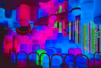 A sleek, neon-lit party pod glowing pink and blue against a black background.