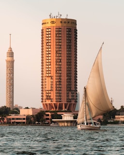 a sailboat in front of a tall building