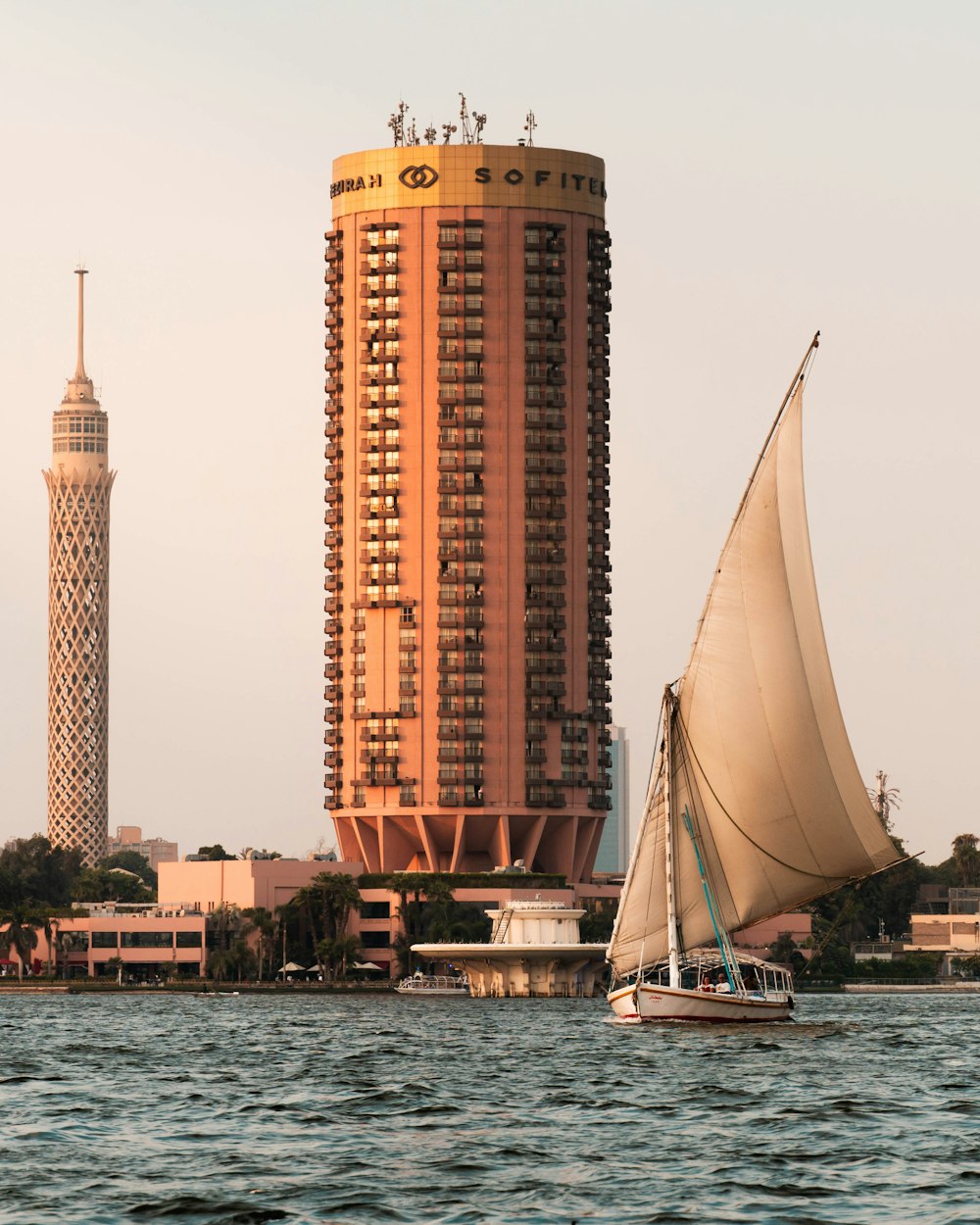 a sailboat in front of a tall building