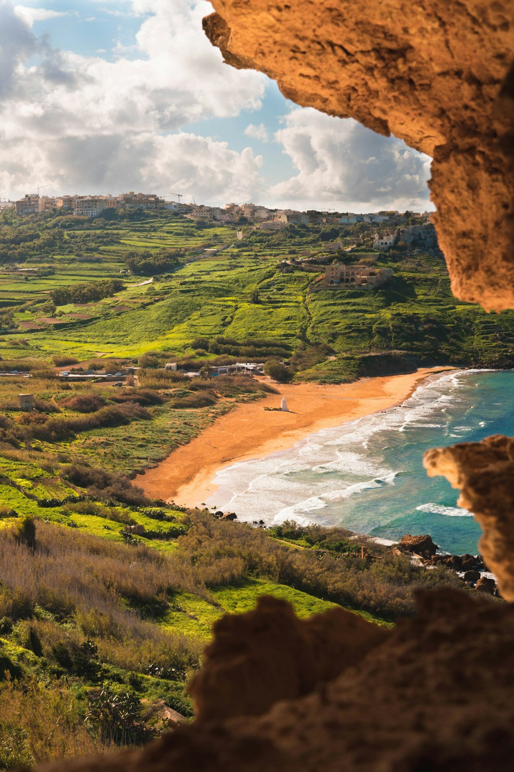 a view of a beach and a city from a cliff