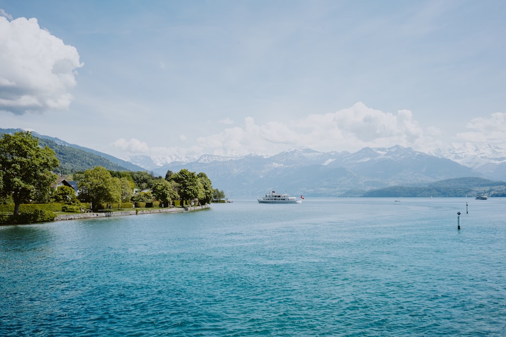 a body of water with a boat in it and mountains in the background