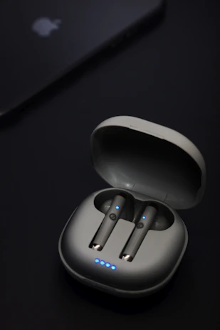 Trendy Bluetooth earbuds resting inside their compact charging case with LED indicators